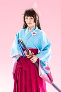 Sakura Wars the Stage cast visual featuring Sakura Amamiya in a blue kimono and pink hakama.